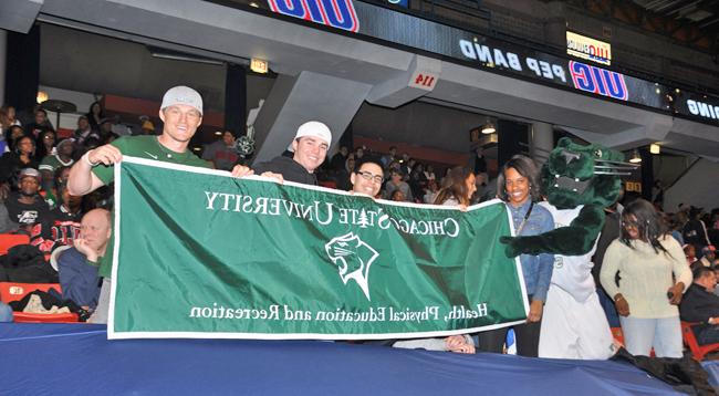 Students actively participating at a CSU basketball game and interacting with the team mascot (Cougar) in the JDC gymnasium